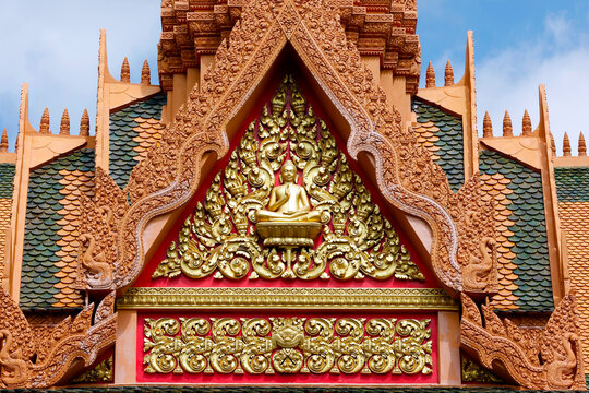 Wat Bo temple. Intricate terracotta temple gable adorned with golden Buddha statue and floral carvings. Siem Reap. Cambodia.