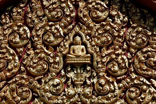 Wat Bo temple. Detailed Khmer-style golden stucco decoration showing Buddha figure framed by spiral leaf patterns. Siem Reap. Cambodia.