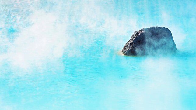 Mystical view of a rock shrouded in steam from the blue pond of Kamado Jigoku ('Furnace Hell'), Beppu, Oita, Kyushu, Japan