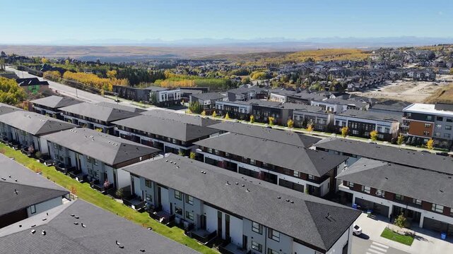 Aerial view of suburban high density houses in autumn along colourful ravines. 