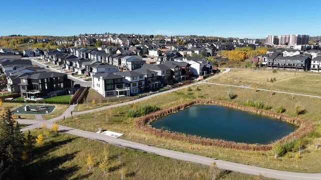 Aerial view of suburban houses in autumn along colourful ravines. 