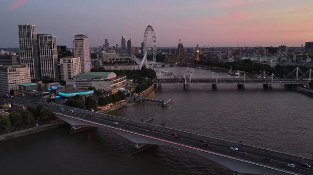 Waterloo Bridge and River Thames, central London, UK. Aerial video footage of moving vehicles crossing the bridge, looking west towards Westminster, Parliament and the surrounding city landmarks.