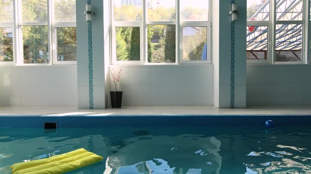 Indoor swimming pool water surface with yellow floating cushion