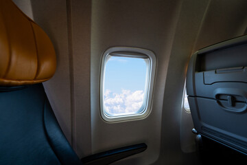 Scenic view from airplane window seat during flight above clouds. Concept of sky journey and air travel © Maria