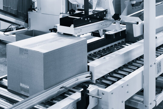 Elements of corton boxes collected in stack. Conveyor line for production of boxes. Machine cuts cardboard boxes from sheets of cardboard. Enterprise for production package.