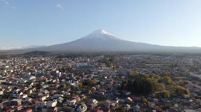 Aerial view of Mount Fuji towering over Fujiyoshida city in Yamanashi, Japan.	