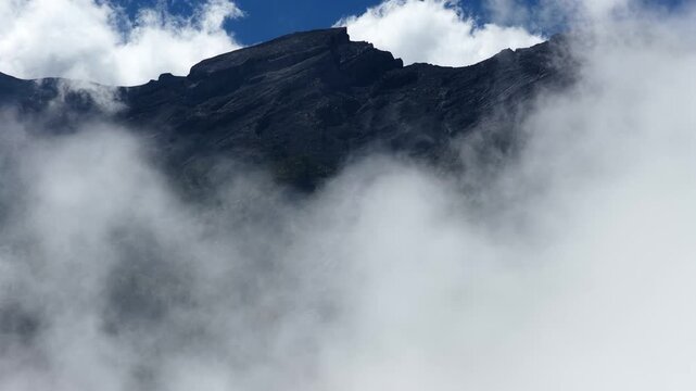 Volcanic Peak Of Mount Agung Covered In Thick White Mist And Clouds In Bali, Indonesia. - aerial shot