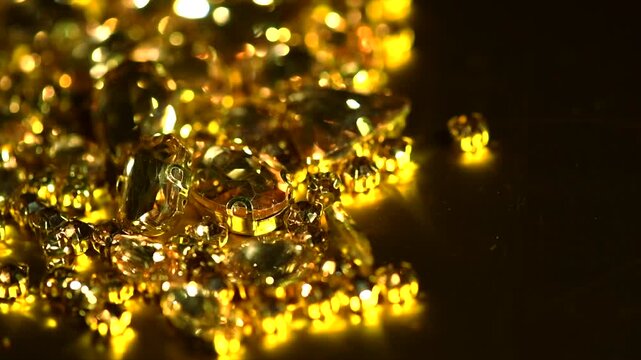 Gold crystals background, gemstones, Sew-on Stones, rhinestones for clothes, blinking gems on black background, rotating backdrop, border. Closeup 