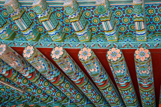 Korean traditional wooden temple double eaves with colorful dancheong painted rafters and lotus patterns for architectural background.