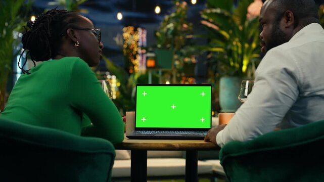 Chroma key laptop used by couple during date on terrace