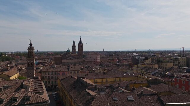 Aerial drone view of Parma, Italy, showcasing the historic city center, terracotta rooftops, churches, green spaces, urban architecture, and the Emilia-Romagna cityscape.