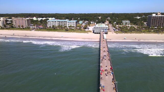 backward flight reveals the full length of an ocean pier at Myrtle Beach.
