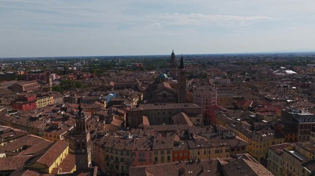 Aerial drone view of Parma, Italy, showcasing the historic city center, terracotta rooftops, churches, green spaces, urban architecture, and the Emilia-Romagna cityscape.