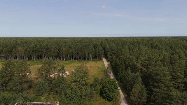 Aerial view of abandoned Soviet-era residential buildings surrounded by dense pine forests in Irbene, Ventspils novads, Latvia.