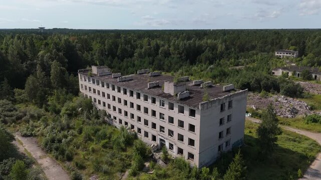 Aerial view of abandoned Soviet-era apartment buildings surrounded by dense forest in Irbene, Ventspils novads, Latvia.