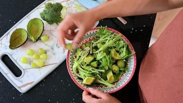 Woman preparing a healthy green salad