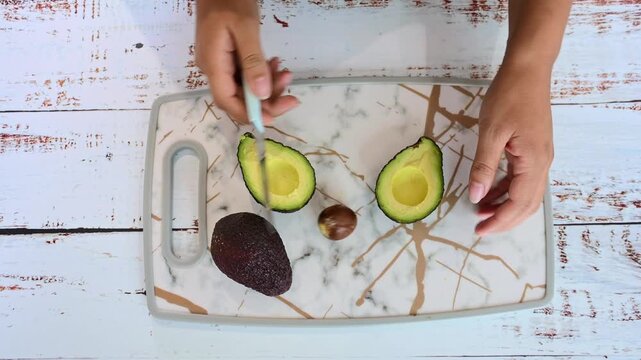 Person peeling a fresh ripe avocado for healthy cooking