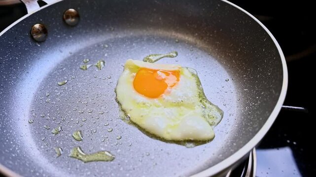 Quail egg frying sunny side up in a pan