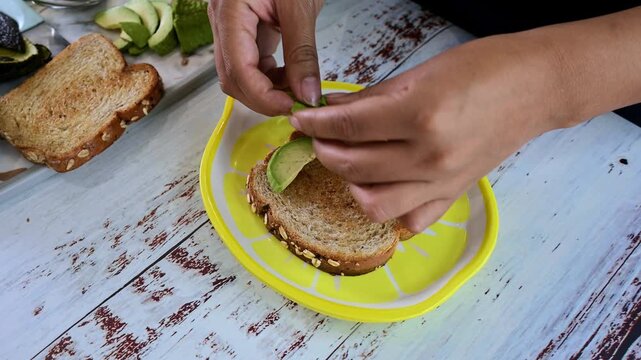 Woman preparing a healthy avocado toast for breakfast