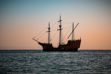 Replica of a historic wooden sailing ship (karaka) on a calm Adriatic Sea at sunset near Dubrovnik, Croatia © anand tripathi