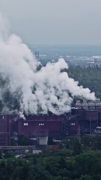 Aerial view of RWE Power AG power plant Niederaussem with steam rising from cooling towers over the industrial facility in Bergheim, Nordrhein-Westfalen, Germany.