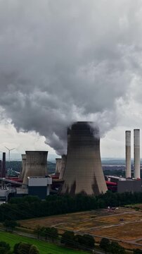 Aerial view of RWE Power AG power plant Niederaussem with cooling towers emitting steam in Bergheim, Nordrhein-Westfalen, Germany.