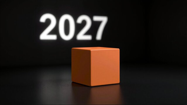 Orange cube on dark surface, glowing 2027 projected behind it.