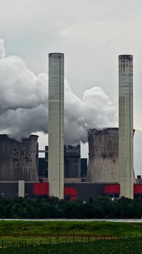 Aerial view of RWE Power AG power plant Niederaussem with cooling towers emitting steam in Bergheim, Nordrhein-Westfalen, Germany.