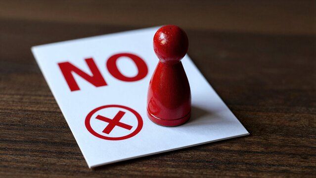 Red pawn stands beside NO sign, symbolizing rejection or refusal.