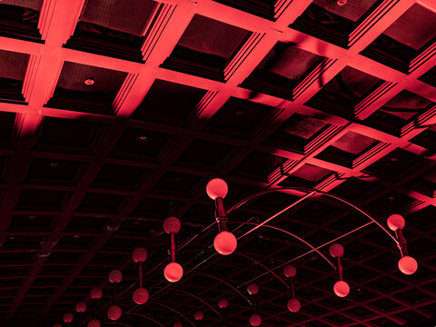 Abstract red architectural ceiling with geometric coffered design and modern light fixtures