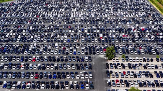 Aerial view of the vast car storage lot at the Port of Bordeaux filled with rows of new vehicles in Bassens, Nouvelle-Aquitaine, France.