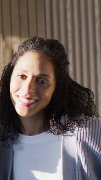 Vertical video: Light causing Black woman tilting head in cardigan, friend coming laughing to greet