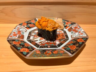 A single piece of premium sea urchin uni gunkan maki sushi on a traditional Japanese plate © bul_Japan