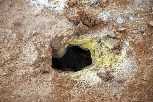 View of a steaming fumarole at Hverir Sulfur Springs in Namafjall, surrounded by yellow sulfur deposits and reddish-brown volcanic soil, Reykjahlid, Thingeyjarsveit, Iceland.