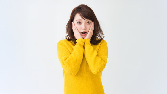 Shocked Japanese Woman with Hands on Cheeks and Copy Space