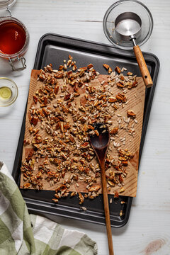 A candied pecan mixture on a cookie sheet cooling.