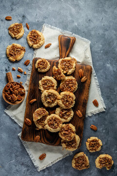 An arrangement of Pecan Pie Cookies on a wooden cutting board. 