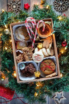 A box filled with a variety of Christmas baking surrounded by greenery.