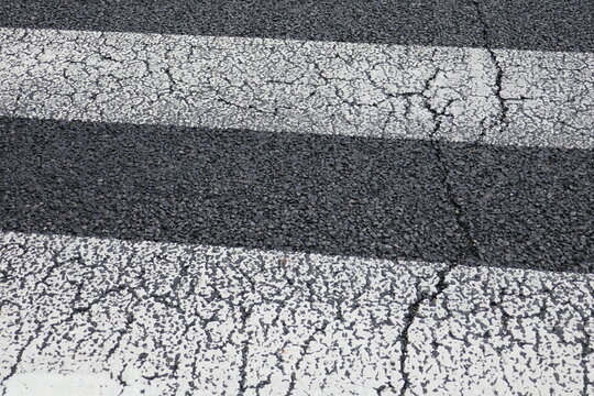 ひび割れたアスファルトの横断歩道