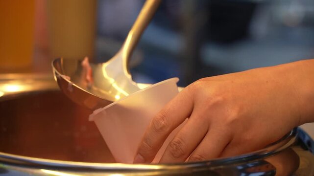 Slow motion of pouring bubble tea into a plastic cup. Trendy lifestyle drink. Night market.