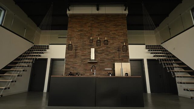 Modern loft kitchen with symmetrical staircases in a luxury open plan industrial style apartment revealing the interior design
