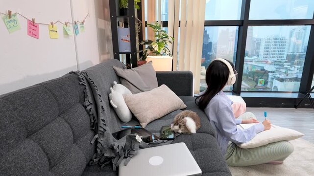 Young Asian Woman Writing with Pet Rabbit in City Apartment