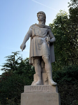 Stone statue of Rollo on an inscribed pedestal, viewed from below against trees and a blue sky - Rouen, France - September 6, 2026