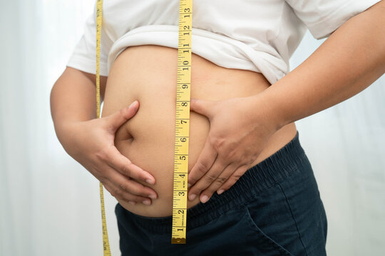 Asian woman use hand to squeeze fat belly big size overweight and obesity.
