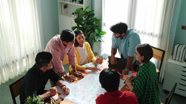Top view of happy creative team putting hands together while drawing mind map. Group of diverse people working together brainstorming marketing idea and sharing plan by using sticky notes. Convocation