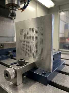 Precision CNC Machining Metal Plate with Drilled Hole Pattern on Industrial Milling Machine Workpiece Fixture Setup in Modern Factory Workshop Environment for Manufacturing Engineering and Metalworkin