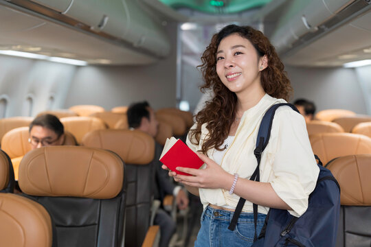 Asian young woman in airplane flight. Asian woman passenger travel by commercial transport flight