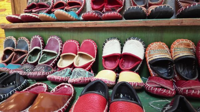 Display of colorful handmade shoes in a local market setting