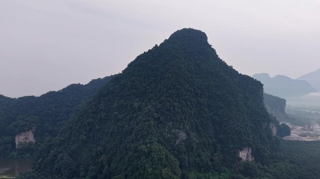 Aerial view of steep karst mountain slopes. Dense greenery covers rocky terrain at Kampar, Perak