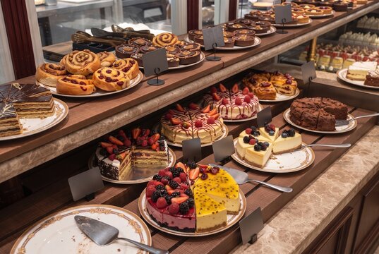 Bakery display case with assorted cakes and fruit tarts